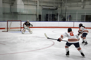 Two SU players push down the rink in the effort to school a goal against RIT.