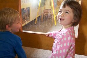 Henry Lough and Xia Snyder, preschool students at the Early Education and Child Care Center, peek in  into another classroom at the center after enjoying snack time. The EECCC, located on South Campus, has 60 students and maintains a low child to teacher ratio. 