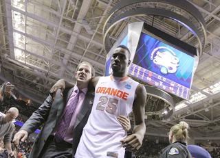 (Left to right) Assistant coach Mike Hopkins walks off the court with Rakeem Christmas #25 after their win over the California Golden Bears.