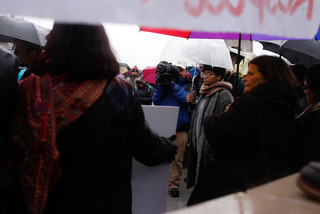 Students and reporters gather around speakers during the rally in front of the Hall of Languages.