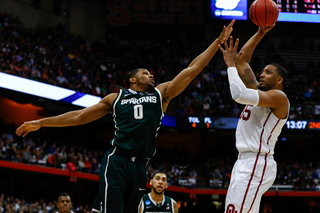 OU's Thomas (35) goes for a shot in the paint, but is blocked by Marvin Clark Jr.