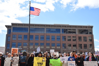 Protesters gather in front of speakers at Clinton Square. 