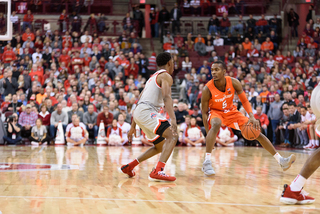 Jalen Carey puts the ball between his legs at the top of the key.