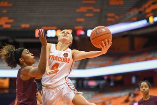 Mangakahia contorts her body around the basket for a layup.