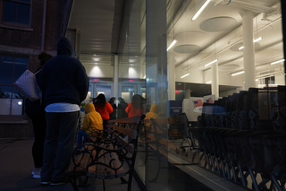 Voters wait in line outside Huntington Hall while poll workers attempt to fix the ballot printer inside.