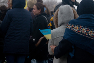 Two women embrace as they watch the Ukrainain flag being raised outside the church. 