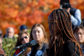 Remembrance Scholar Sifan Hunde speaks about the life of the SU student she represents during the rose laying ceremony. The sun shines down on Hunde as she reads a statement in remembrance of her student and the other 269 victims. 